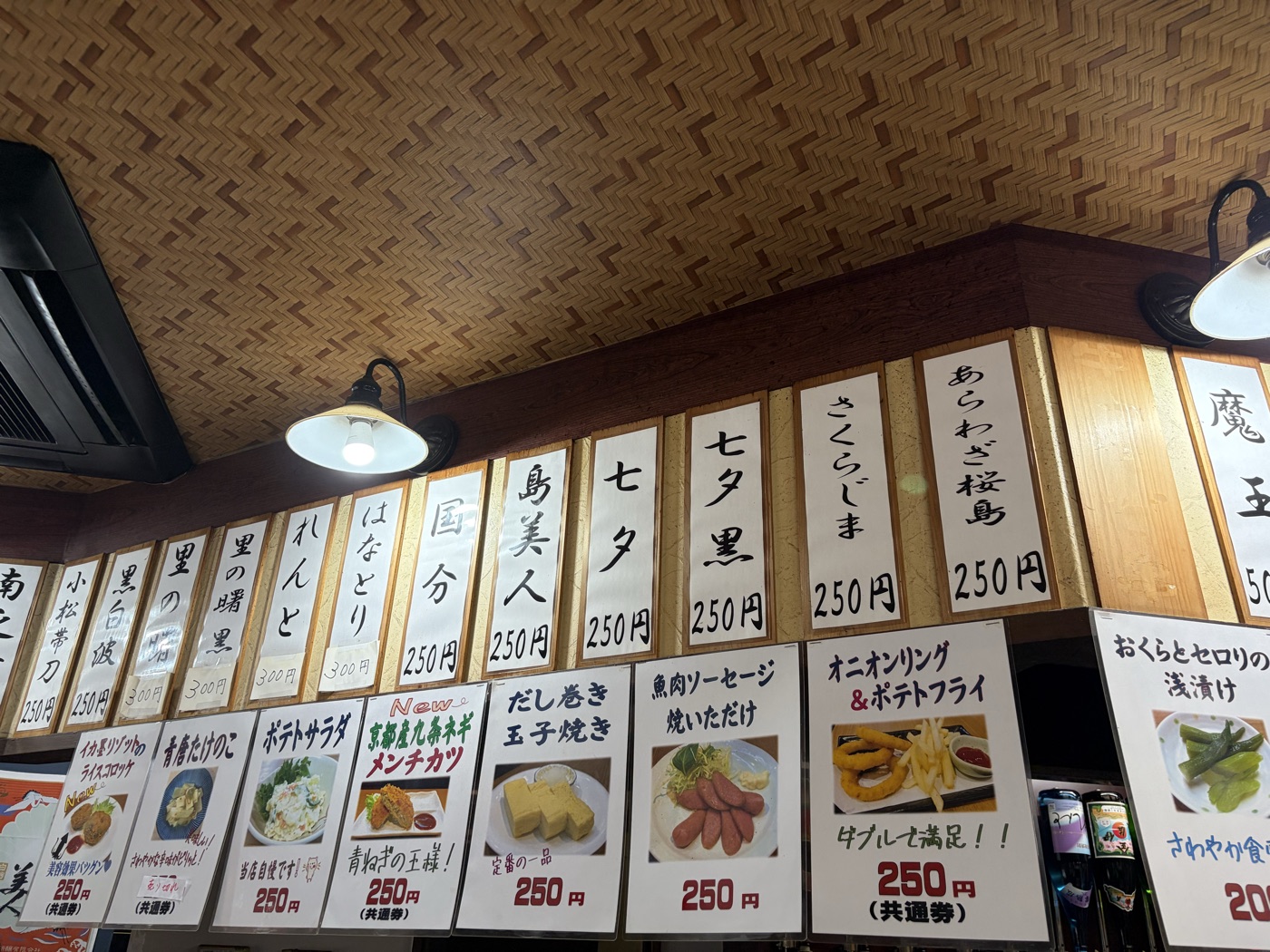 キリツ中央駅前店の店内。焼酎の銘柄札がずらりと並ぶ壁