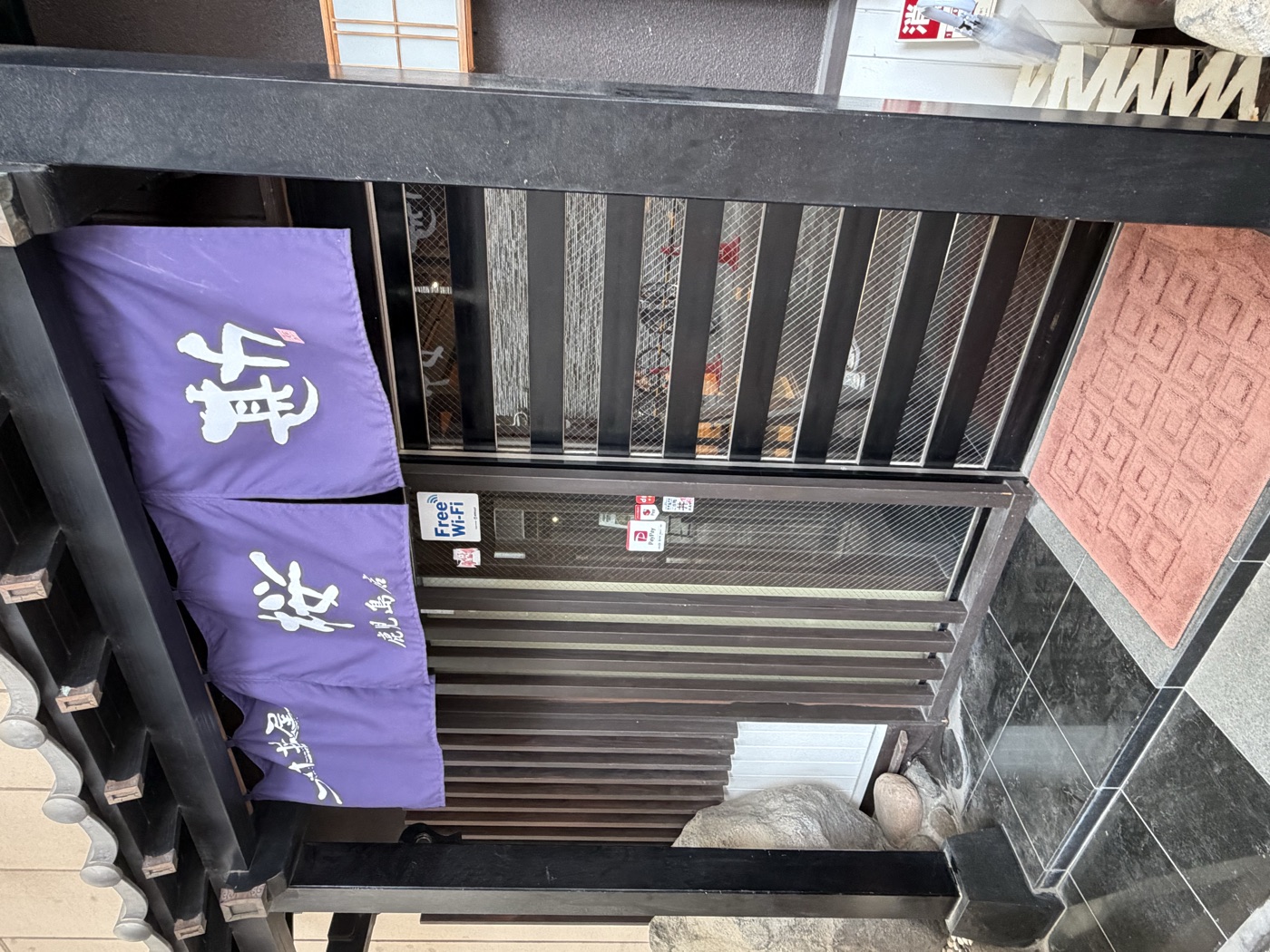 桜勘鹿児島店の外観。紫の暖簾に白抜きで「桜勘」
