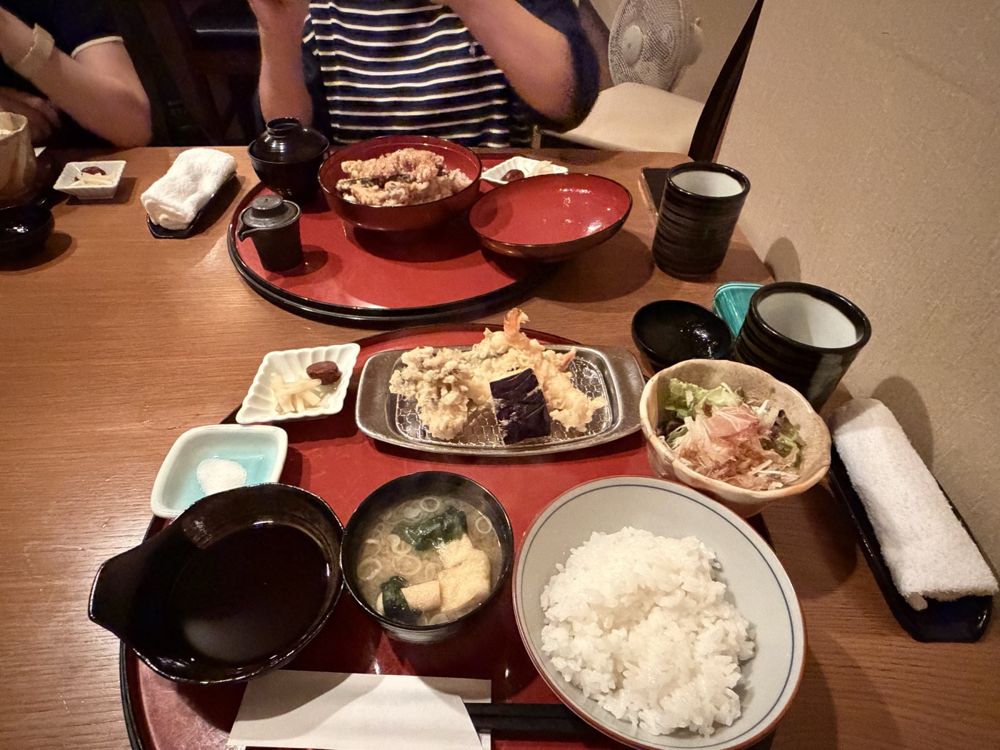 天友の店内で天ぷら定食と天丼を囲むテーブル。えび天やなす天にごはん・味噌汁・サラダ・天つゆと塩
